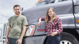 Husband and wife team truck drivers with their truck