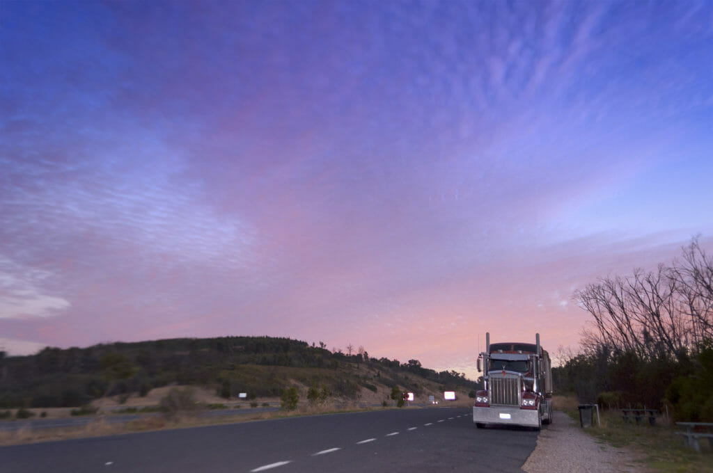Large truck on an empty road at dusk